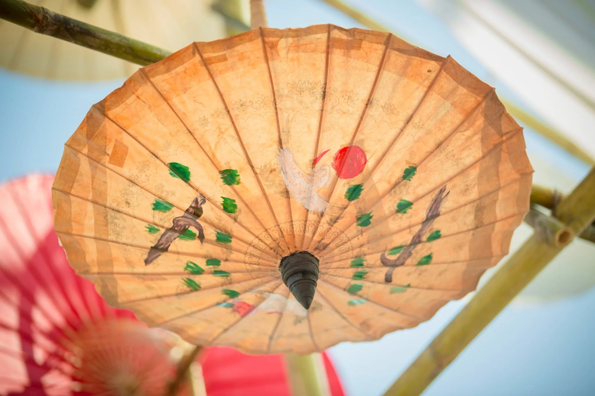 A handmade handpainted parasol hanging upside down
