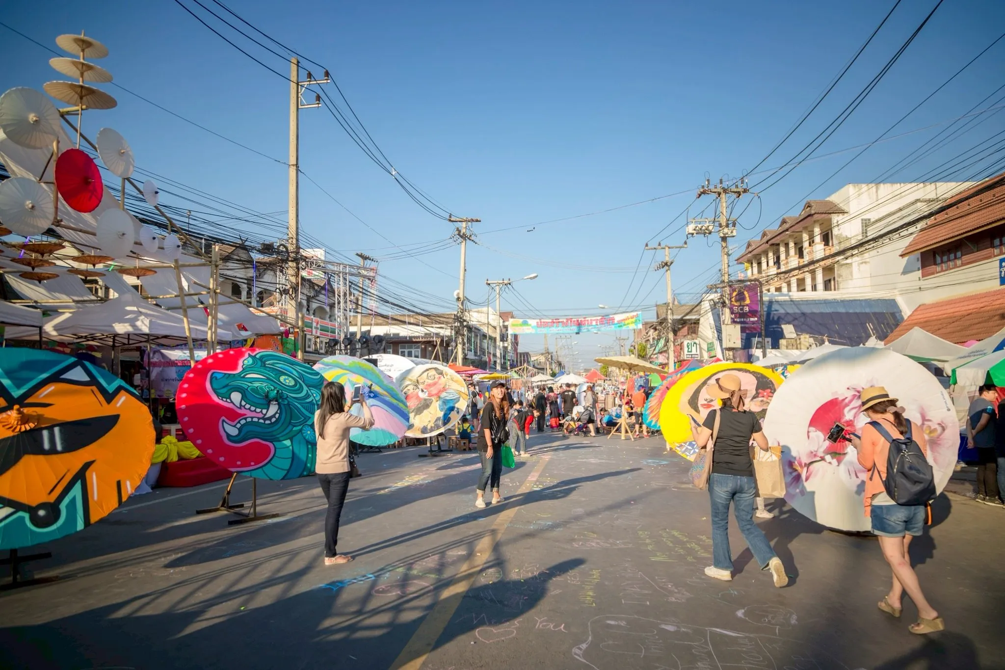 Street adorned with traditional large parasols during Bo Sang Umbrella Festival