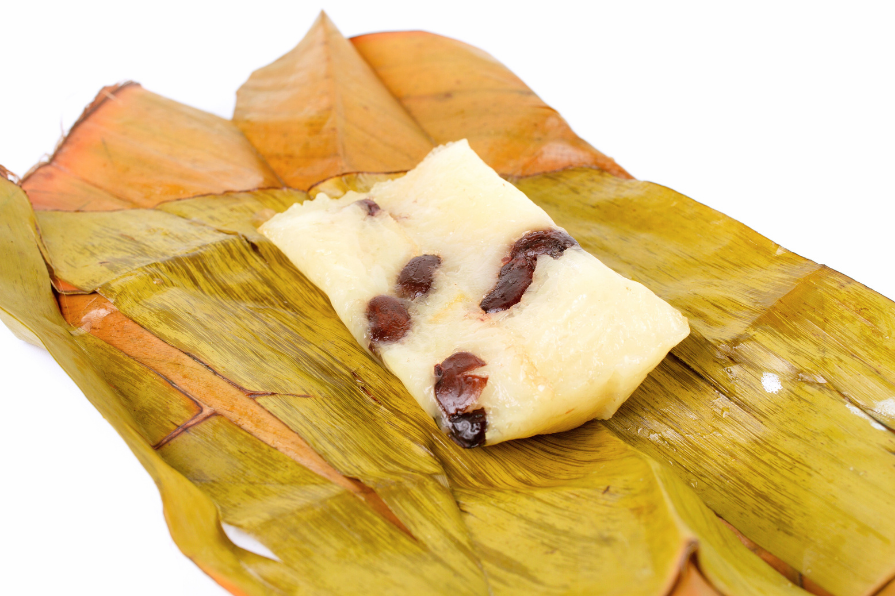 khao tom mad or coconut rice with banana and red bean unwrapped from banana leaves