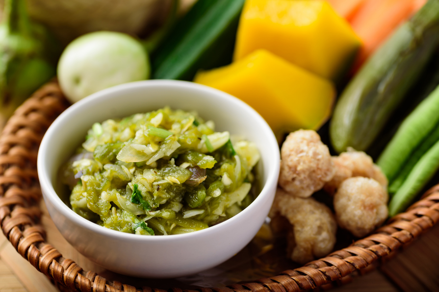nam prik noom in a ramiken next to a vegetable medley