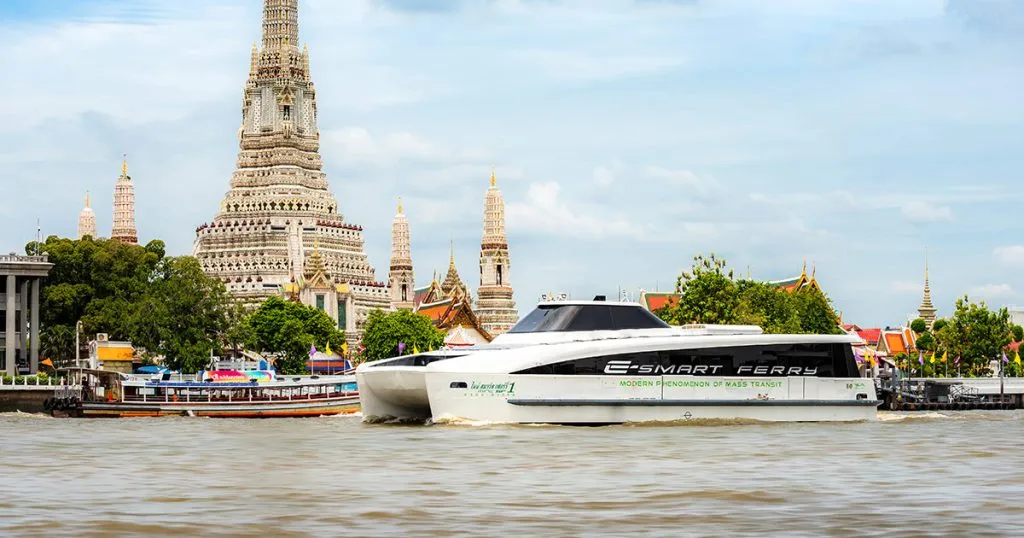 MINE Smart ferry on the Chao Phraya river with the famous Wat Arun temple in the background.