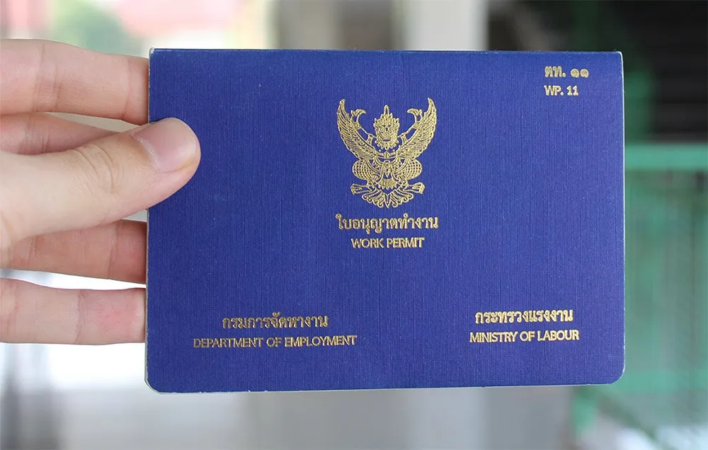 a small blue booklet with garuda a logo placed on the center, with the text that reads "work permit"