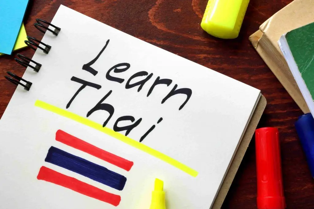 A notebook with the words "Learn Thai" written on it.