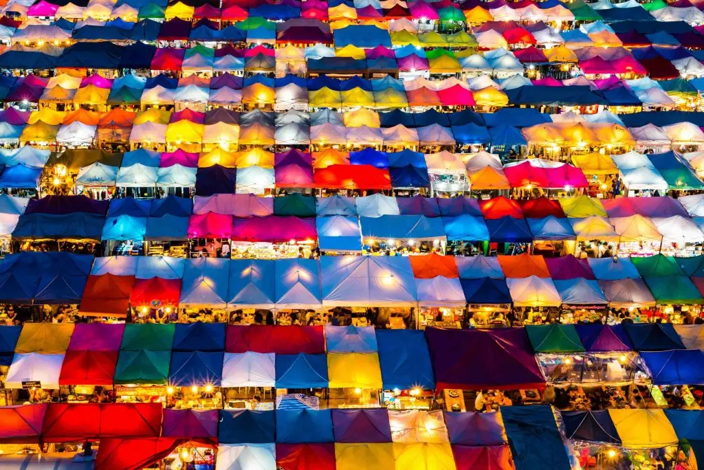 View from above of a series of colorful stalls from a Thai night market.
