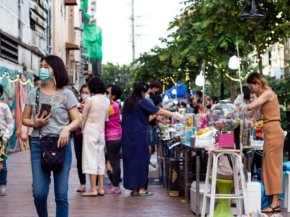 Visitors and stores at Khlong Ong Ang's vibrant walking street.