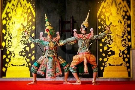 Two Khon dancers positioned opposite each other in ornate Khon costumes.