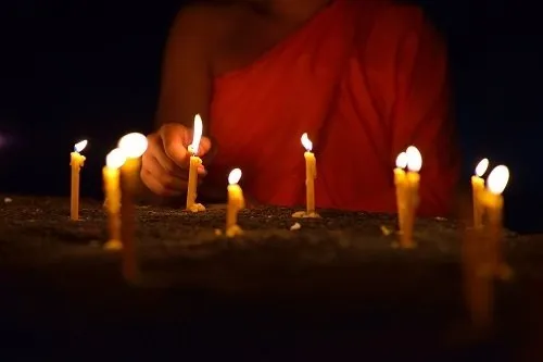 A monk lighting candles.