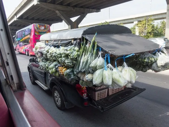 A food truck loaded with different vegetables and other pantry staples.
