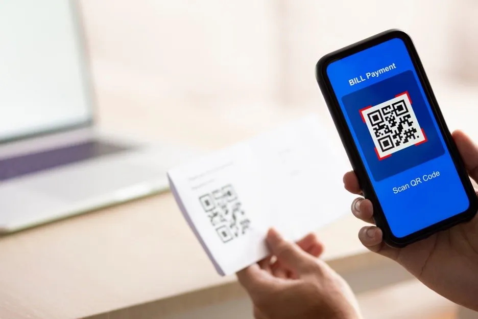 A smartphone being used to scan a QR code for bill payment.