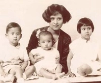 Monochrome photograph of Her Royal Highness Princess Srinagarindra with her three young children.