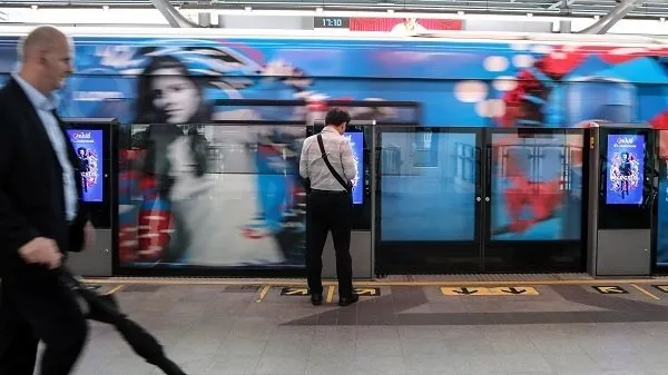 A person standing and looking down outside a train platform. 