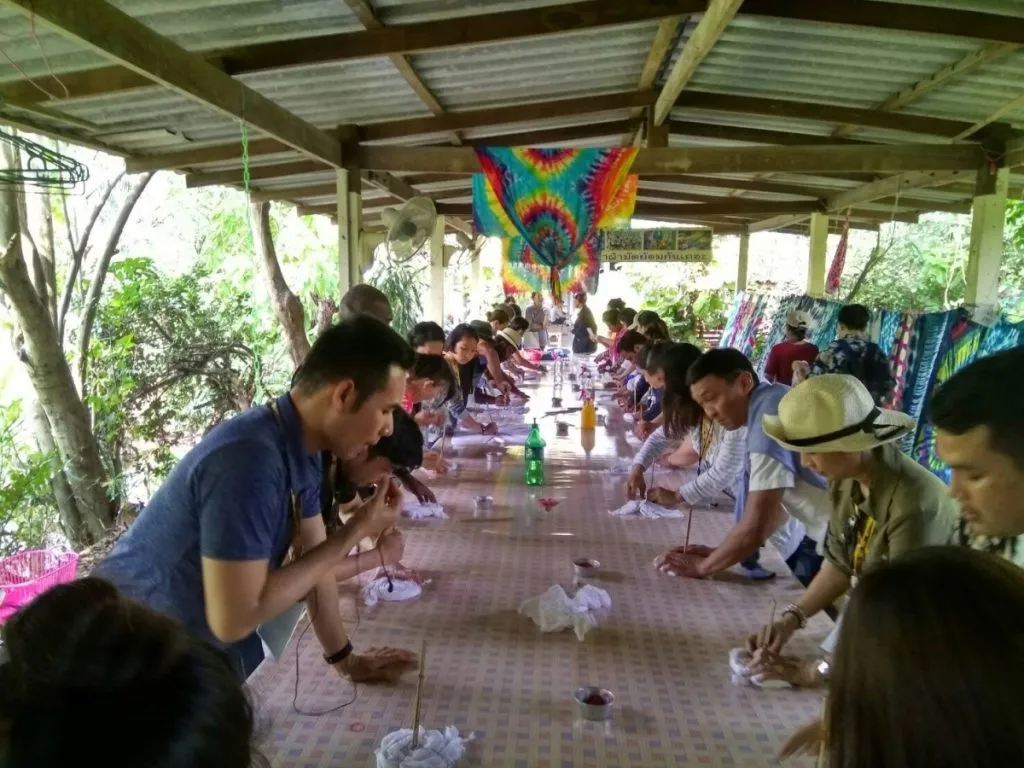 A series of people tie-dying cloth.