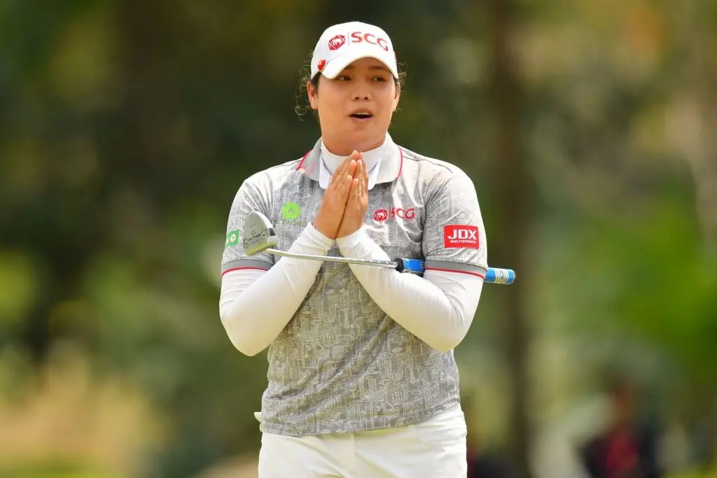 Pro Thai golfer Ariya Jutanugarn holding her club between her arms. 