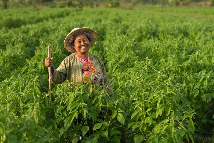 A female farmer smiling in the field.
