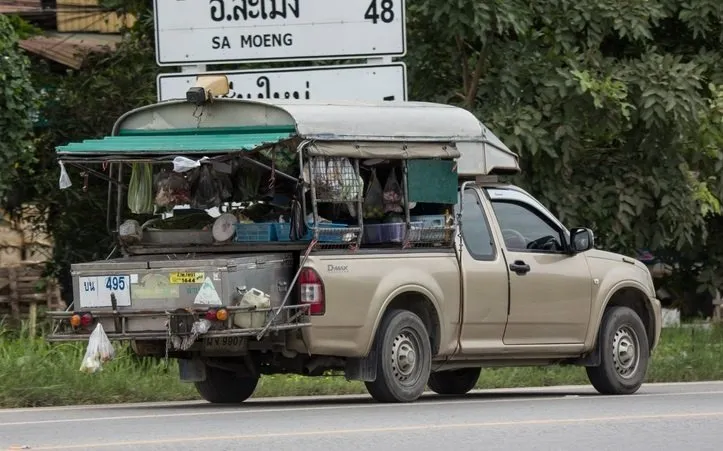 A food truck with vegetables and other produce in ice boxes.