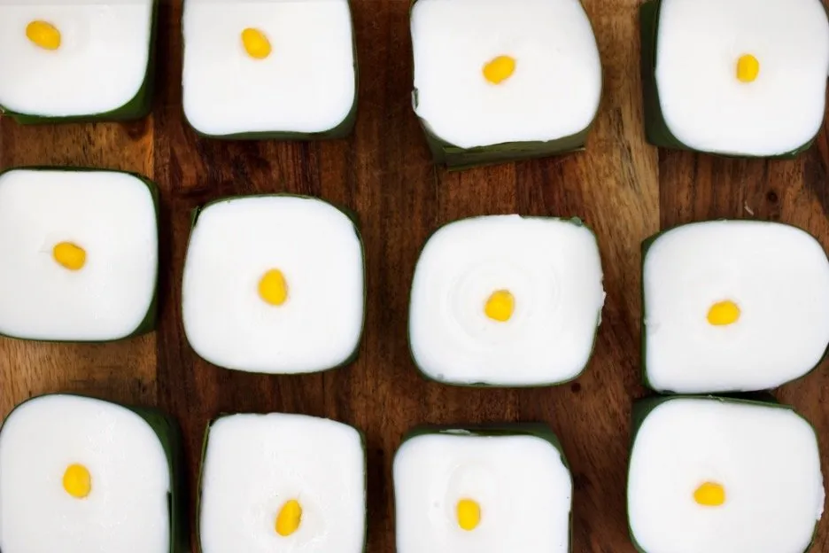 Khanom Tako: two-tier dessert made of sweet chestnut bottom and coconut topping held with pandan leaf.