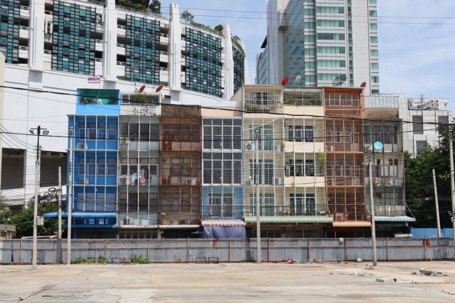 Tenement housing in the foreground with modern developments looming behind.