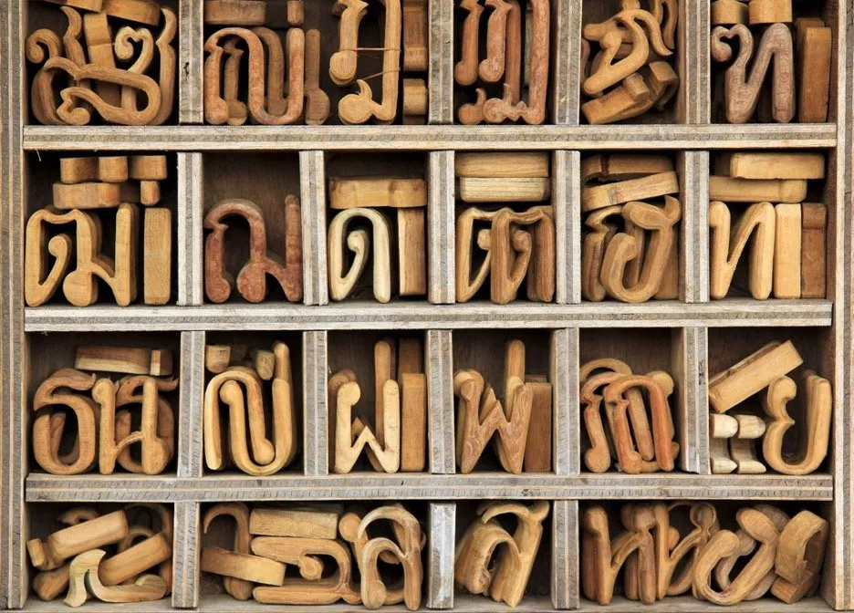 Woodcut Thai alphabet neatly organized in a wooden typecase.
