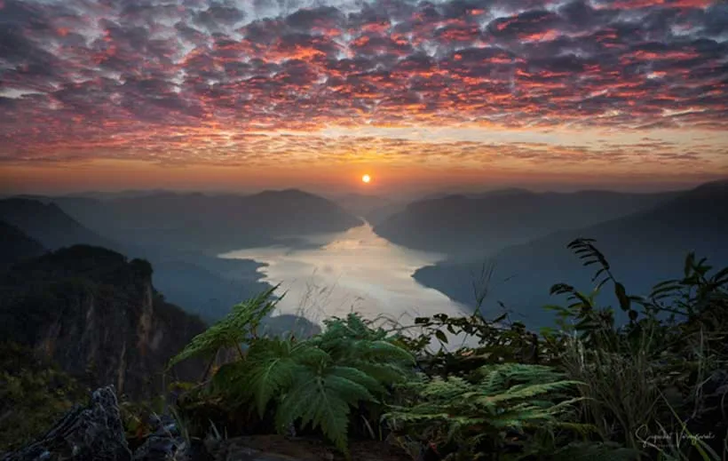 Sunset over a river and mountains.