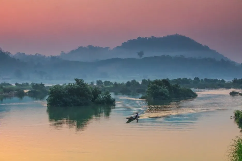 A boatman navigating the Mekong River in the early morning in Nong Khai, Thailand.