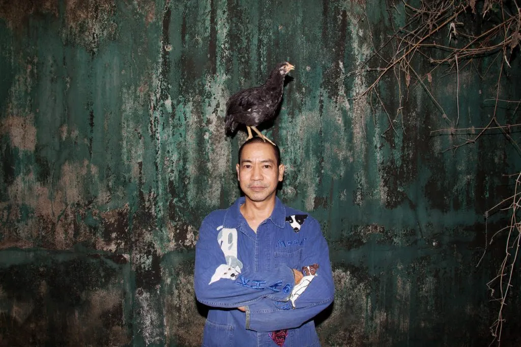 Jakkai Siributr, one of the leading textile artists of Southeast Asia, with a chicken on his head.