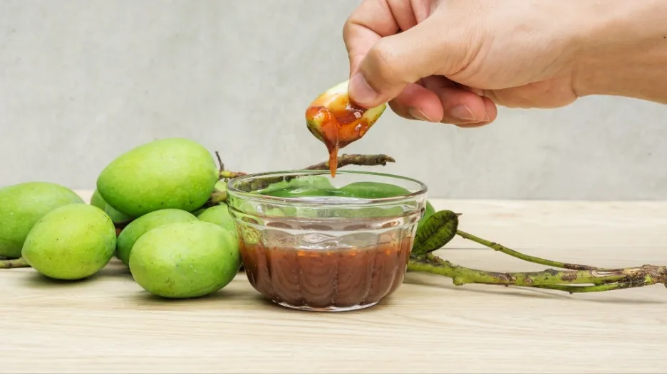 Green mango dipped in nam pla wan (spicy dips).