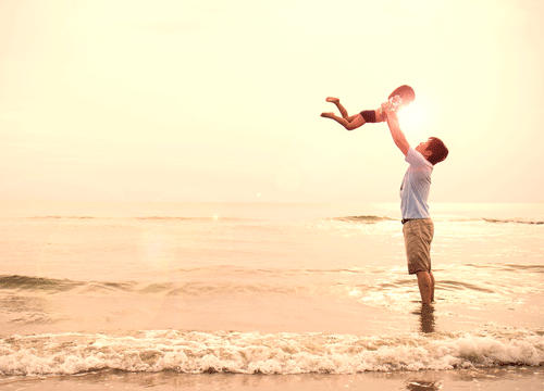 A father holding up a little girl