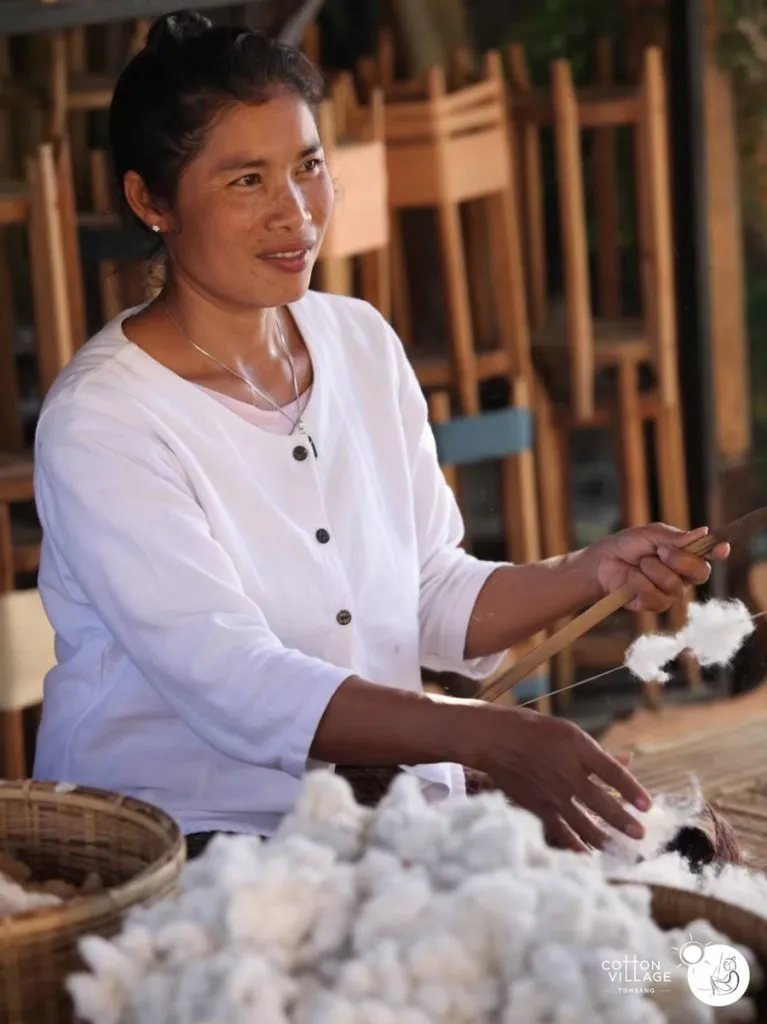 A lady preparing yarn to turn into fabric for weaving and embroidery.