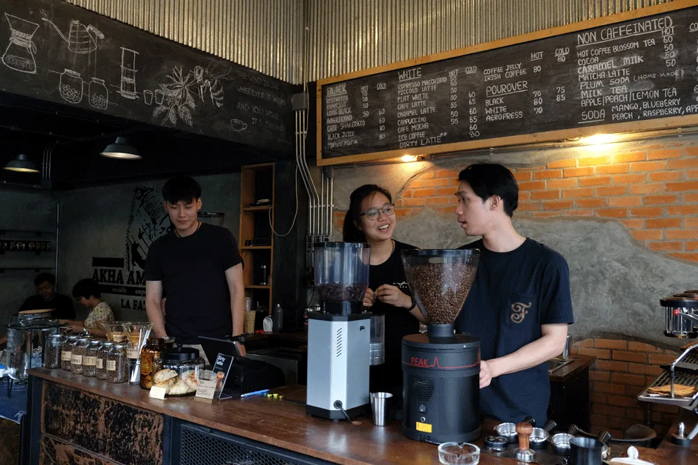 Three baristas brewing artisanal coffee.