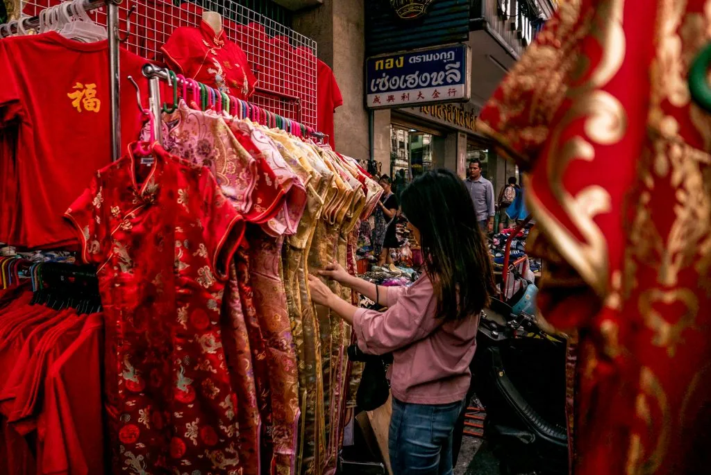 A person shopping for a red qipao in China Town, Bangkok, Thailand