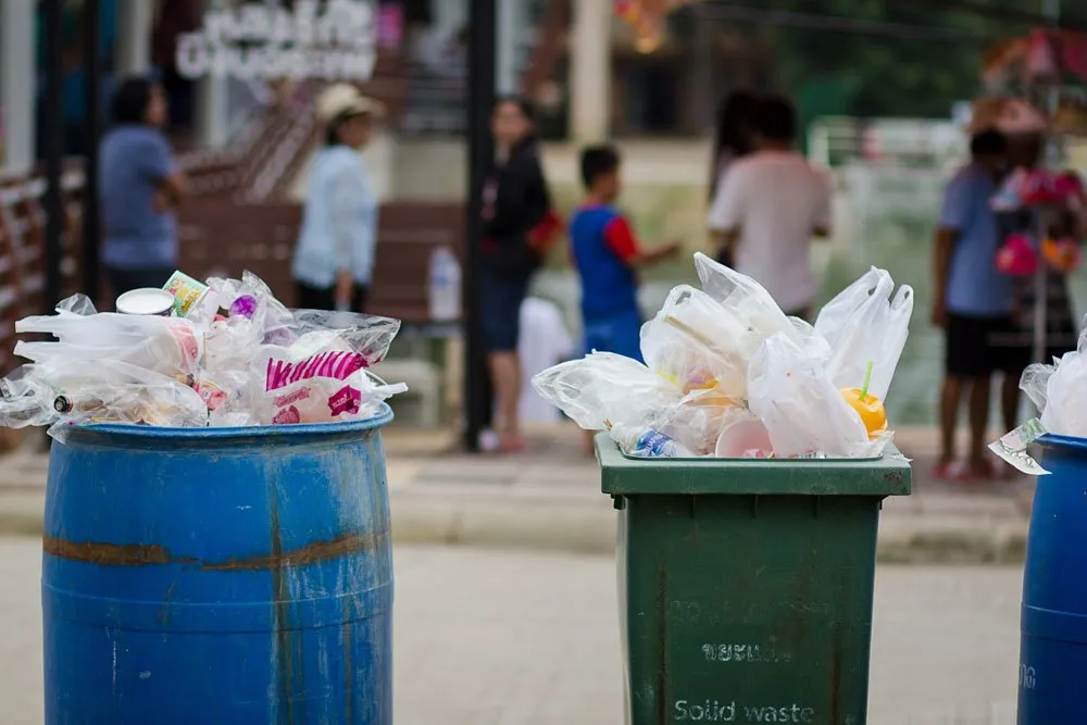 Bins full of trash from restaurants and street food stalls on the side of the road