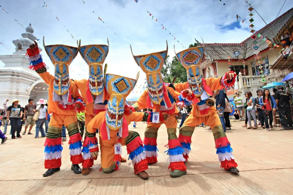 A group of men wearing traditional ghost costumes at Phi Ta Khon Festival