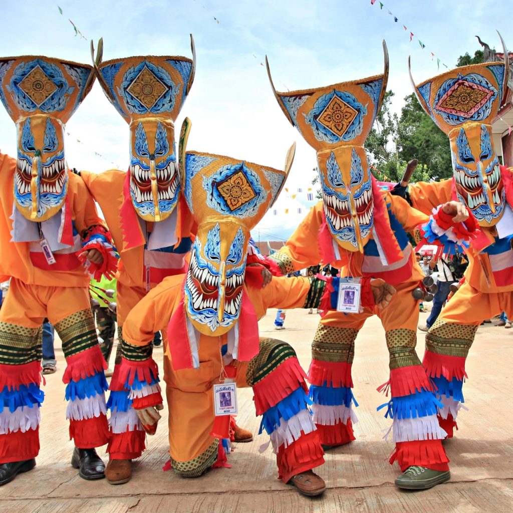 A group of people wearing ghost masks at the Phi Ta Khon Festival or Ghost Festival