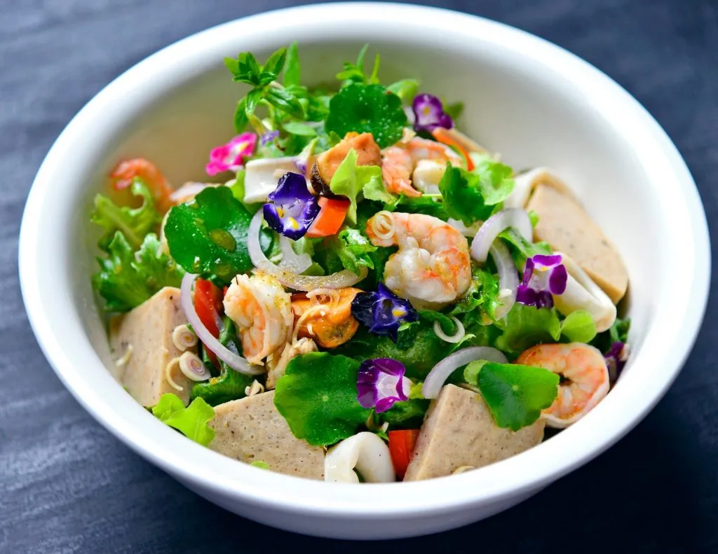 A salad dish with fresh vegetables and edible flowers from the farm