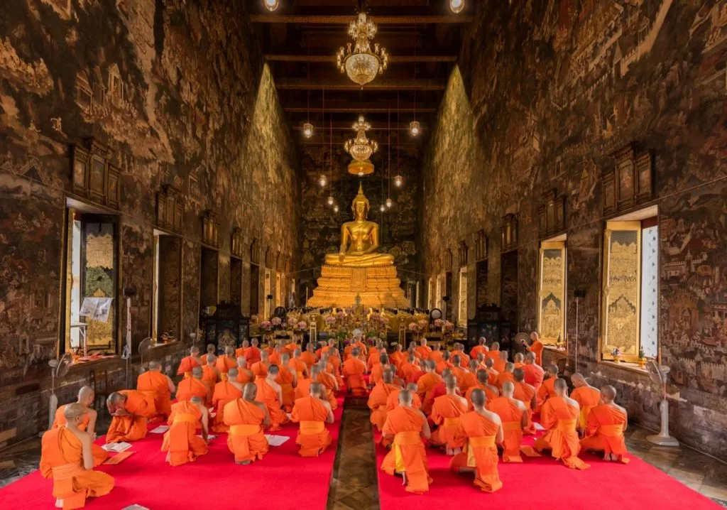 Buddhist monks paying respect to a Buddha statue on the first day of rainy season retreat