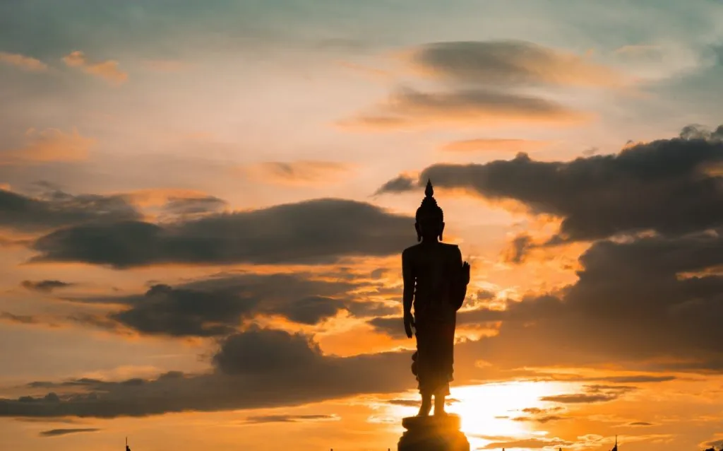 Silhouette of Buddha statue at sunset