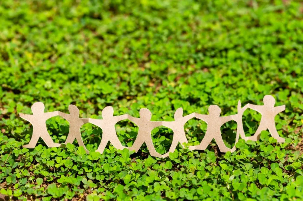 Human chain paper on green plant