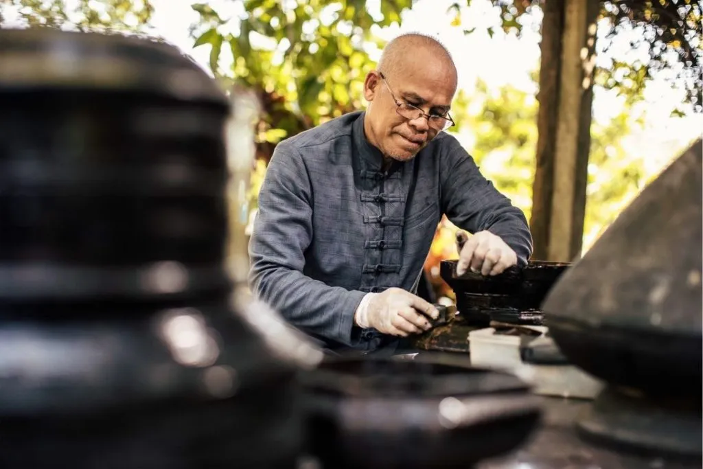 Jukkit Suksawat preparing lacquered rattan frames for inlay