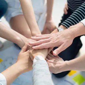 People putting their hands in the middle to show team spirit