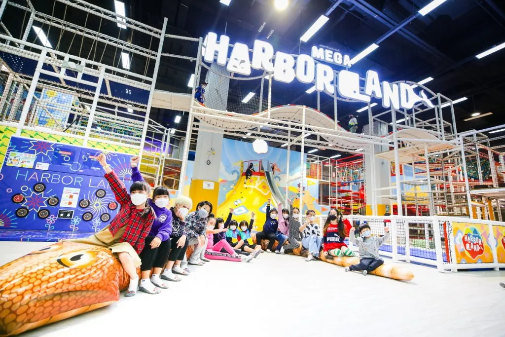 Kids playing and posing for a picture in front of the MEGA HarborLand