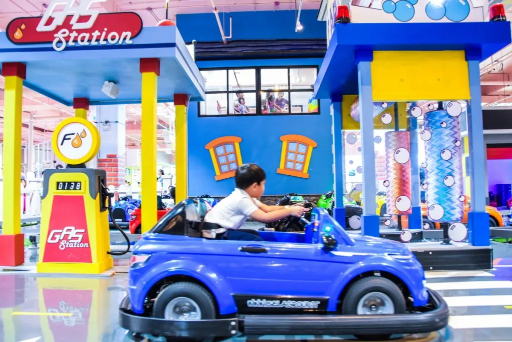 A kid driving an electric toy car at the MEGA HarborLand