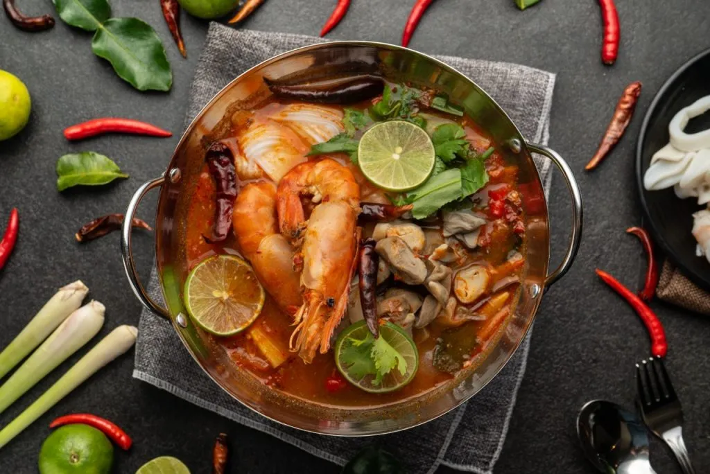 A well-known Thai dish called Tom Yum Goong with ingredients such as kaffir lime leaves, lemongrass, galanga, chili peppers, cilantro, and shallots