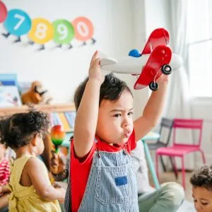 A preschooler playing and enjoying his airplane toy