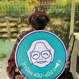 Auntie Noi holding the Kad Pap Pap logo