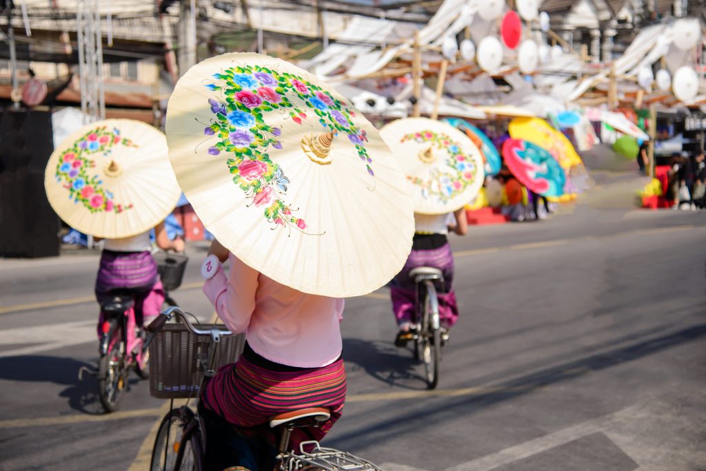A group of women in traditional group costume holding umbrellas during the Bo Sang Umbrella Festival