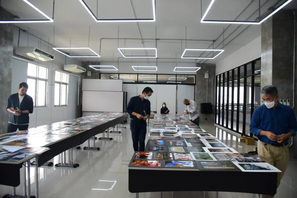 Professional photographers and adjudicators from RMUTT and Baan Lae Suan magazine reviewing entries submitted to the photo contest