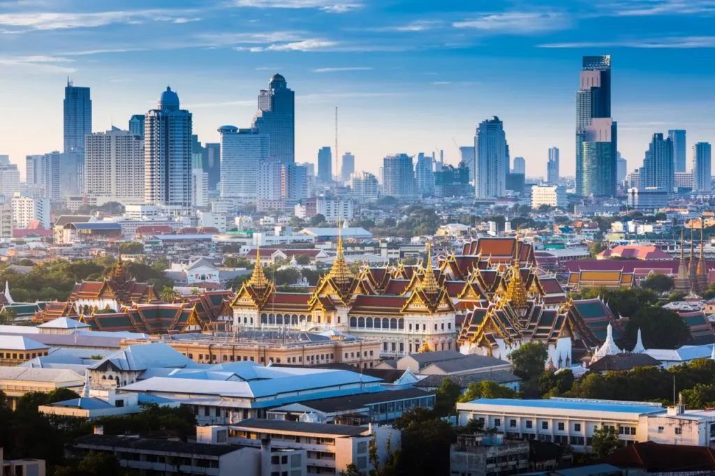 The Golden Grand Palace of Bangkok in the foreground and the skyscraper view of cityscrape in the background