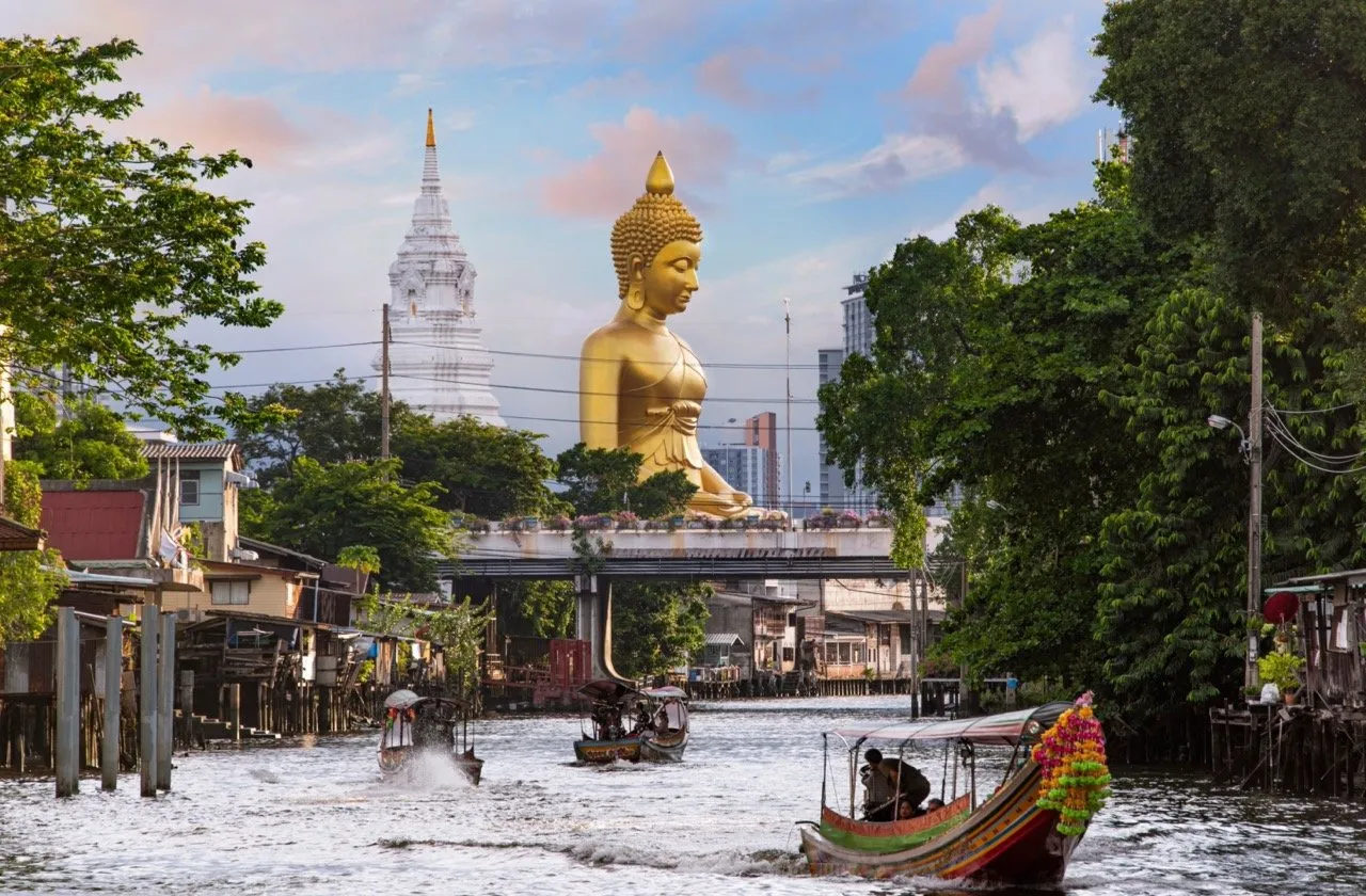 A view of Wat Paknam Phasi Charoen Temple with a stunning Buddha statue and Bangkok's canal