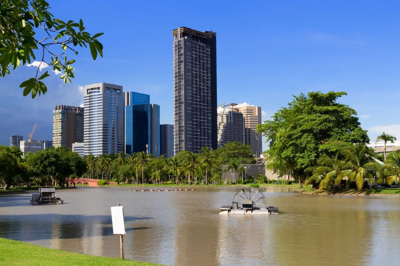 Aerators in a lake at Lumphini Park with a view of downtown Bangkok