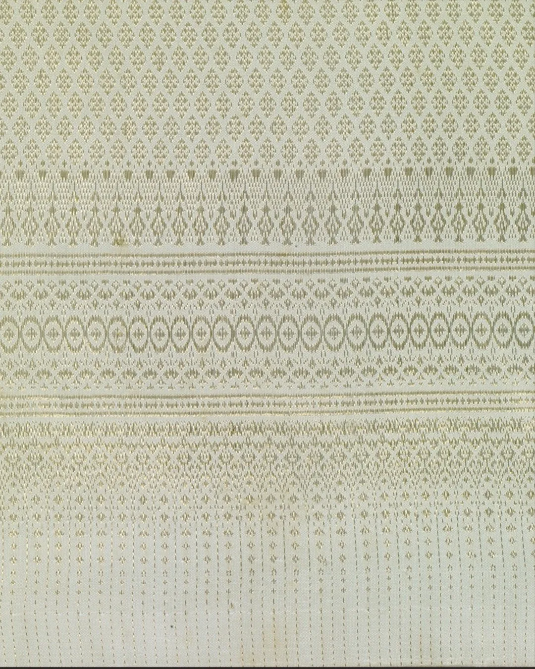 A close-up of the Amarin traditional Thai dress shows bands of silk brocade that help to create visual interest and subtly lengthen the skirt with its vertical patterns.